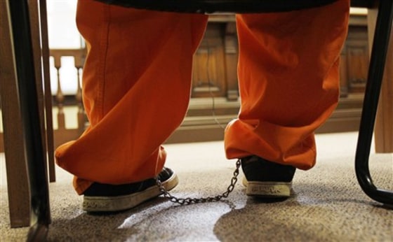 A ten-year old boy sits with his legs in irons in a courtroom Monday in Millersburg, Ohio.